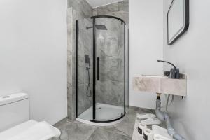 ein Badezimmer mit Dusche, Toilette und Waschbecken in der Unterkunft Plush Hotel Downtown Toronto in Toronto