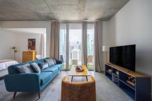 a living room with a blue couch and a tv at Chic Studio by Brickell & Miami Beach WD Pool Gym in Miami