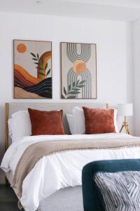 a bedroom with a bed with three paintings on the wall at Chic Studio by Brickell & Miami Beach WD Pool Gym in Miami +27 photos
