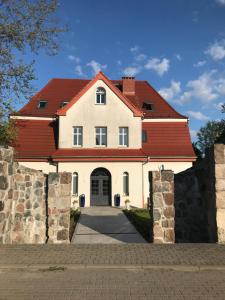 a large white house with a red roof at Willa Pod Platanem in Bytów