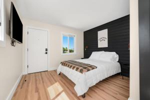 a bedroom with a white bed and a black wall at The Central Block Bend Motel in Bend