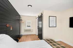 a bedroom with a white bed and a black headboard at The Central Block Bend Motel in Bend +20 photos