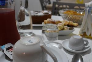 un tavolo con bollitore per tè e piatti di cibo di Triathlon B&B a Lecce