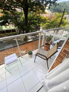 a patio with a chair and a table on a balcony at Caminho do Mar Hotel in Guarujá