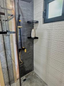 a shower stall with a phone on the wall at Forest Whisper Lux - A-frame cabin with private hot tub in Kovačka Dolina