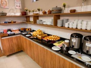 a breakfast buffet in a restaurant with food on a counter at Caminho do Mar Hotel in Guarujá
