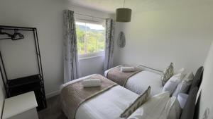 a bedroom with two beds and a window at Donrae in Portree