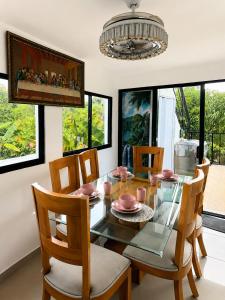 a dining room with a glass table and chairs at Villa Spa Mega Relax in San Francisco de Macorís +5 photos