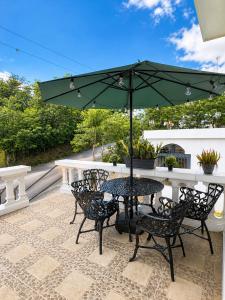 a table and chairs with an umbrella on a patio at Villa Spa Mega Relax in San Francisco de Macorís