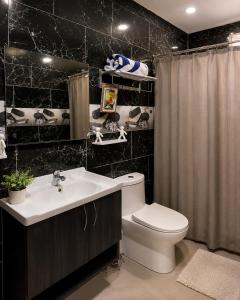 a bathroom with a toilet and a sink and a shower at Villa Spa Mega Relax in San Francisco de Macorís