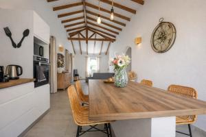 a kitchen and dining room with a table with a vase of flowers at L Échappée Belle Havre de paix au cœur du verger in Le Moule +23 photos