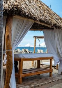 a bed in a straw hut on the beach at Posada Las Rosas Inn in Quizandal