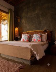 a bedroom with a bed with pillows and a window at Posada Las Rosas Inn in Quizandal