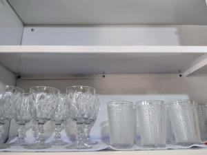a row of wine glasses sitting on a shelf at Casa na área central com 3 quartos in São Pedro