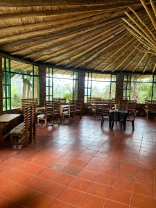 a room with tables and chairs and windows at Hotel Rokas de Suesca in Suesca