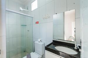 a bathroom with a toilet and a sink and a mirror at Pousada La Belle in Maragogi +27 photos