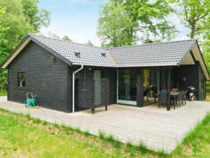 a black house with a patio and a table at 8 person holiday home in Vig in Vig