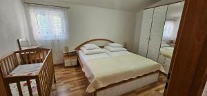 a bedroom with a bed and a mirror and a chair at Big Apartments in Grebaštica