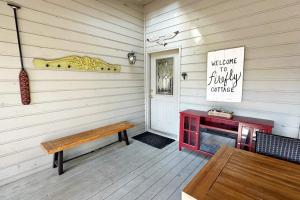 a porch with a bench and a table and a door at Firefly Cottage in Edisto Beach +32 photos