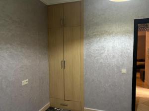 a room with wooden cabinets and a wall at Cozy Appartement for vacation in Agadir
