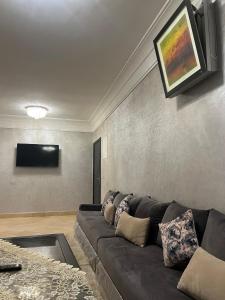 a living room with a couch and a flat screen tv at Cozy Appartement for vacation in Agadir