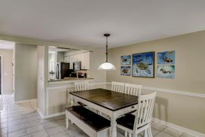 a dining room with a wooden table and white chairs at Courtside 56 in Hilton Head Island
