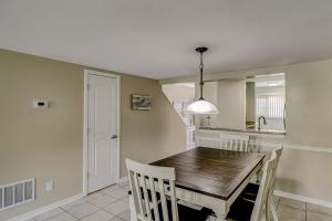 a dining room with a wooden table and a kitchen at Courtside 56 in Hilton Head Island