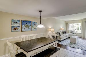a living room with a table and a couch at Courtside 56 in Hilton Head Island +29 photos