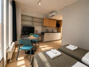a room with two beds and a table and a kitchen at Emajõe Apartments in Tartu +65 photos