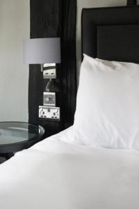 a bedroom with a bed and a table with a lamp at The Windmill in Maidstone