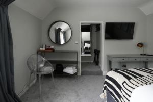 a bedroom with a bed and a mirror and a chair at The Windmill in Maidstone