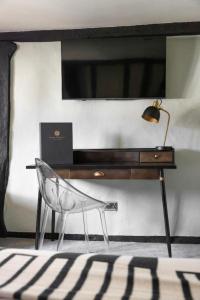 a desk with a chair next to a desk with a lamp at The Windmill in Maidstone