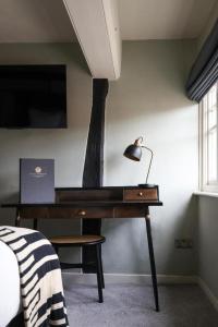 a desk with a lamp on it in a bedroom at The Windmill in Maidstone +7 photos
