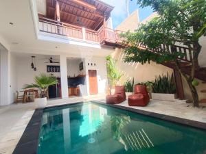 a swimming pool in front of a house at Artha Sadia Villa 1 Seseh Beach in Cemagi