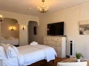 a bedroom with a bed and a flat screen tv at The Vurpillat in Hermosa Beach +138 photos