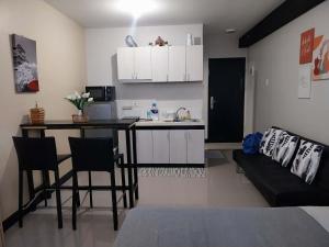 a kitchen and living room with a table and a couch at Studio Type Furnished Condo in Lapu Lapu City