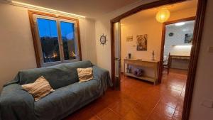 a living room with a couch and a bedroom at La Casa Azul en Ortigueira in Santa Marta de Ortigueira