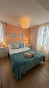 a bedroom with a large bed with towels on it at La Casa Azul en Ortigueira in Santa Marta de Ortigueira