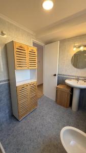 a bathroom with a sink and a toilet and a mirror at La Casa Azul en Ortigueira in Santa Marta de Ortigueira +26 photos