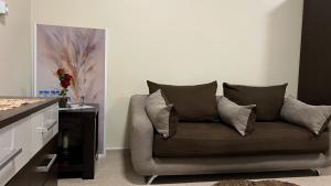 a living room with a couch with pillows on it at Stylish 2BR Escape Near Muscat City Centre in Mawāliḩ
