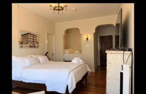 a bedroom with a white bed and a television at The Vurpillat in Hermosa Beach
