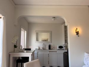 a white kitchen with a sink and a microwave at The Vurpillat in Hermosa Beach