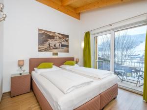a bedroom with a large bed and a large window at Hochkönigblick I in Werfenweng