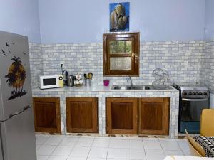 a kitchen with a sink and a microwave at CHEZ VERO Ziguinchor AGNACK in Ziguinchor +5 photos