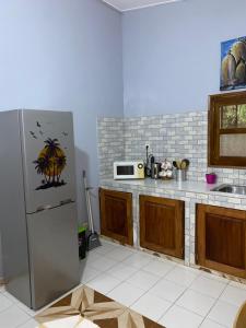 a kitchen with a refrigerator and a microwave at CHEZ VERO Ziguinchor AGNACK in Ziguinchor