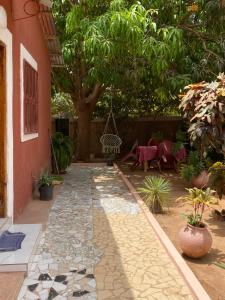 a courtyard with a tree and a swing at CHEZ VERO Ziguinchor AGNACK in Ziguinchor