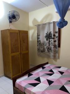 a bedroom with a bed and a dresser at CHEZ VERO Ziguinchor AGNACK in Ziguinchor