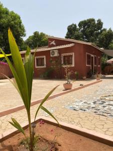 a house with a palm tree in front of it at CHEZ VERO Ziguinchor AGNACK in Ziguinchor
