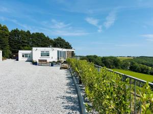 a caravan parked on a gravel road next to a fence at The Waterfront House in Kinsale, hosted by Exquisite Holiday Homes in Dunderrow