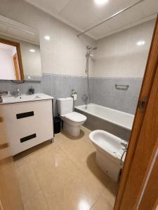 a bathroom with a toilet and a sink and a tub at Skandi home in Gran Alacant +3 photos